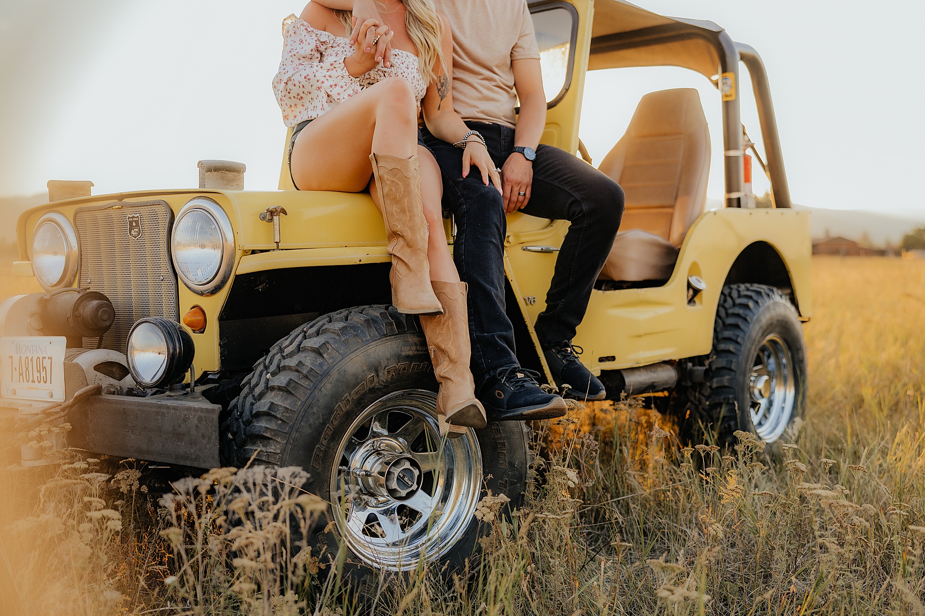 Montana Couple sit on hood of yellow jeep