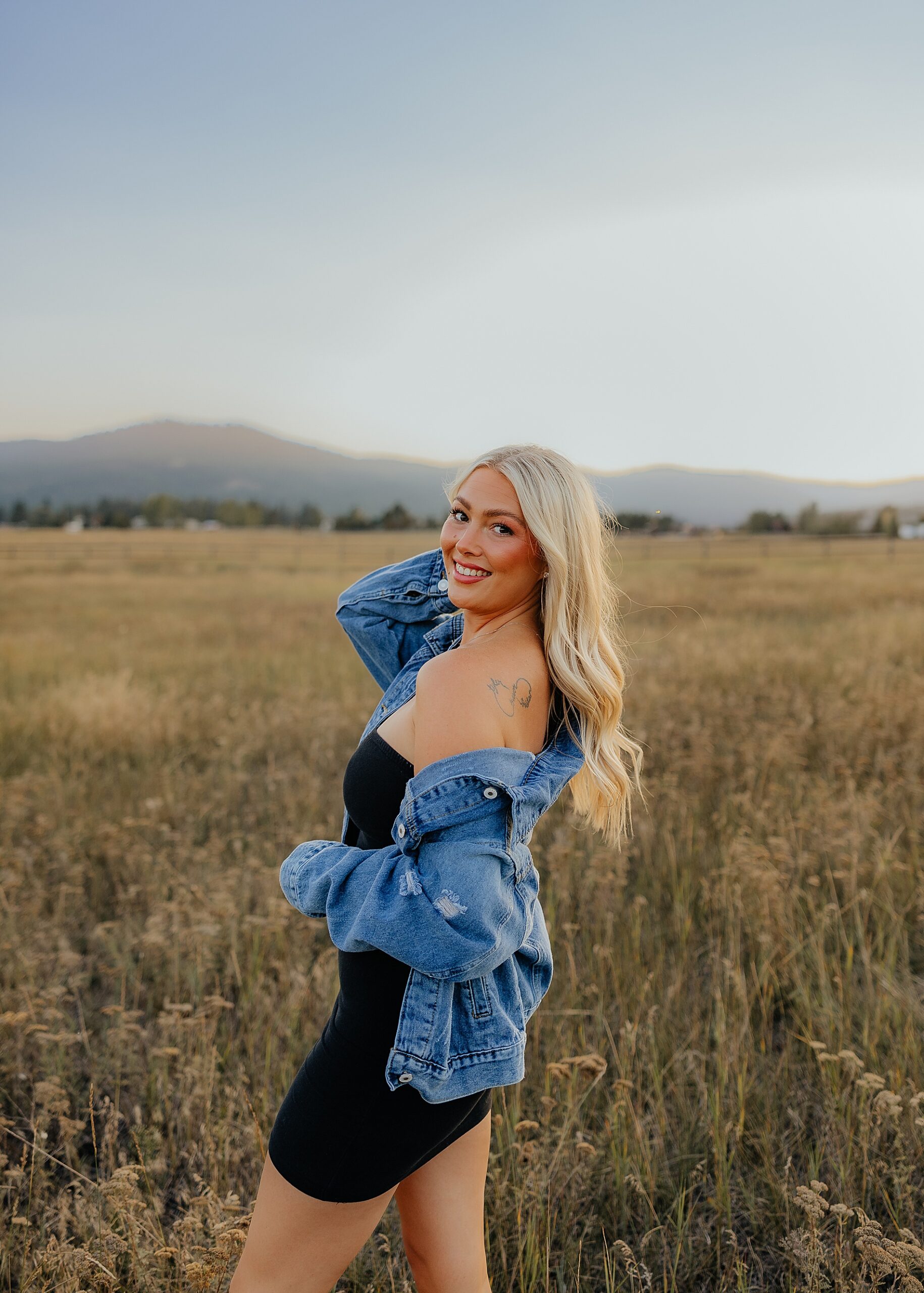 Woman stands in golden field in Montana 