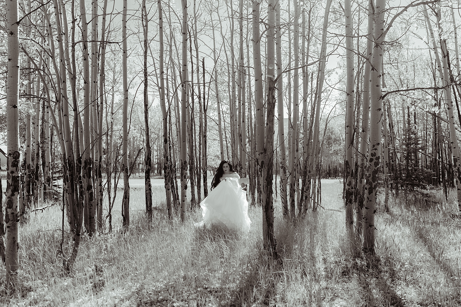 bride walking through woods to first look location