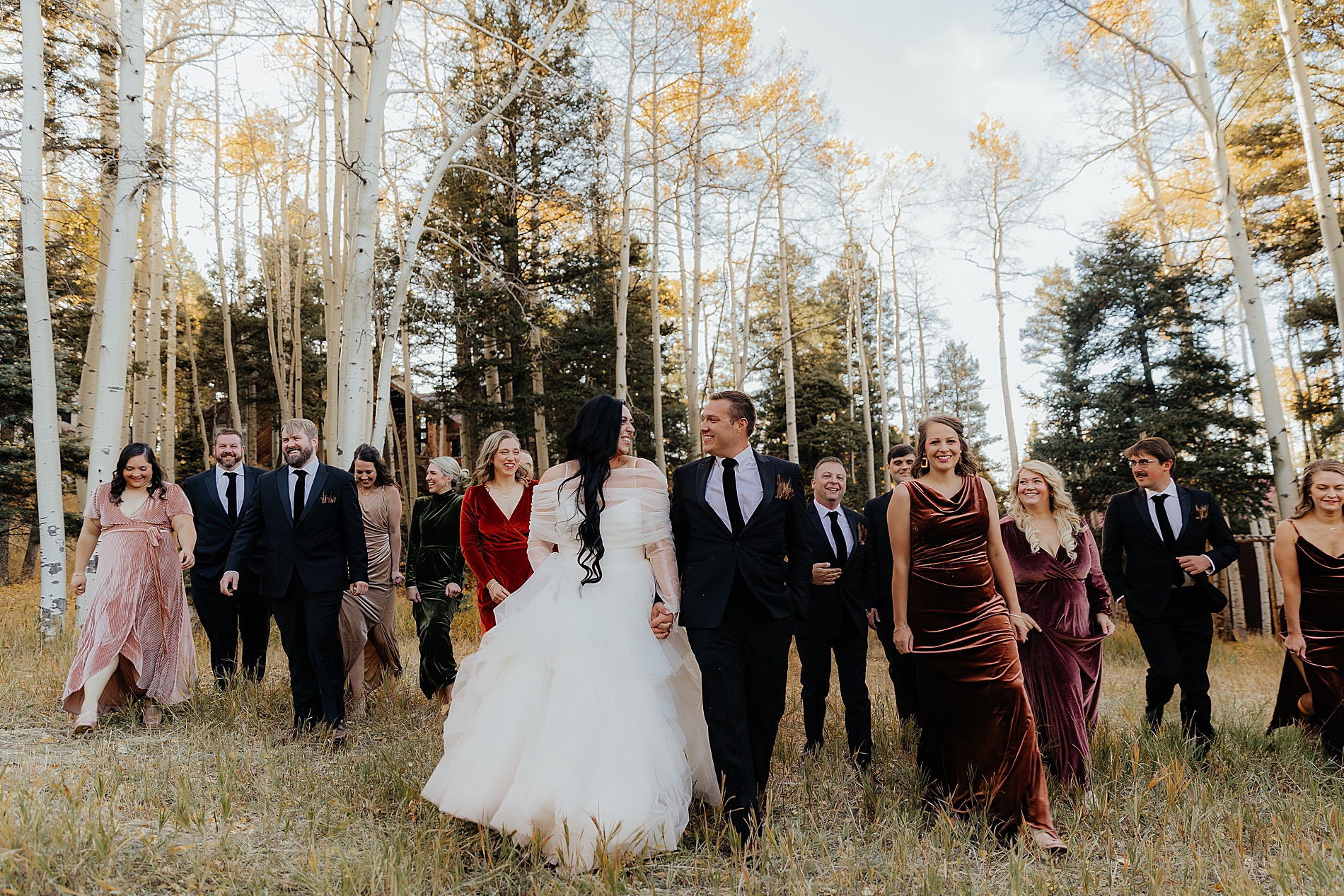 bride and groom walk with wedding party 