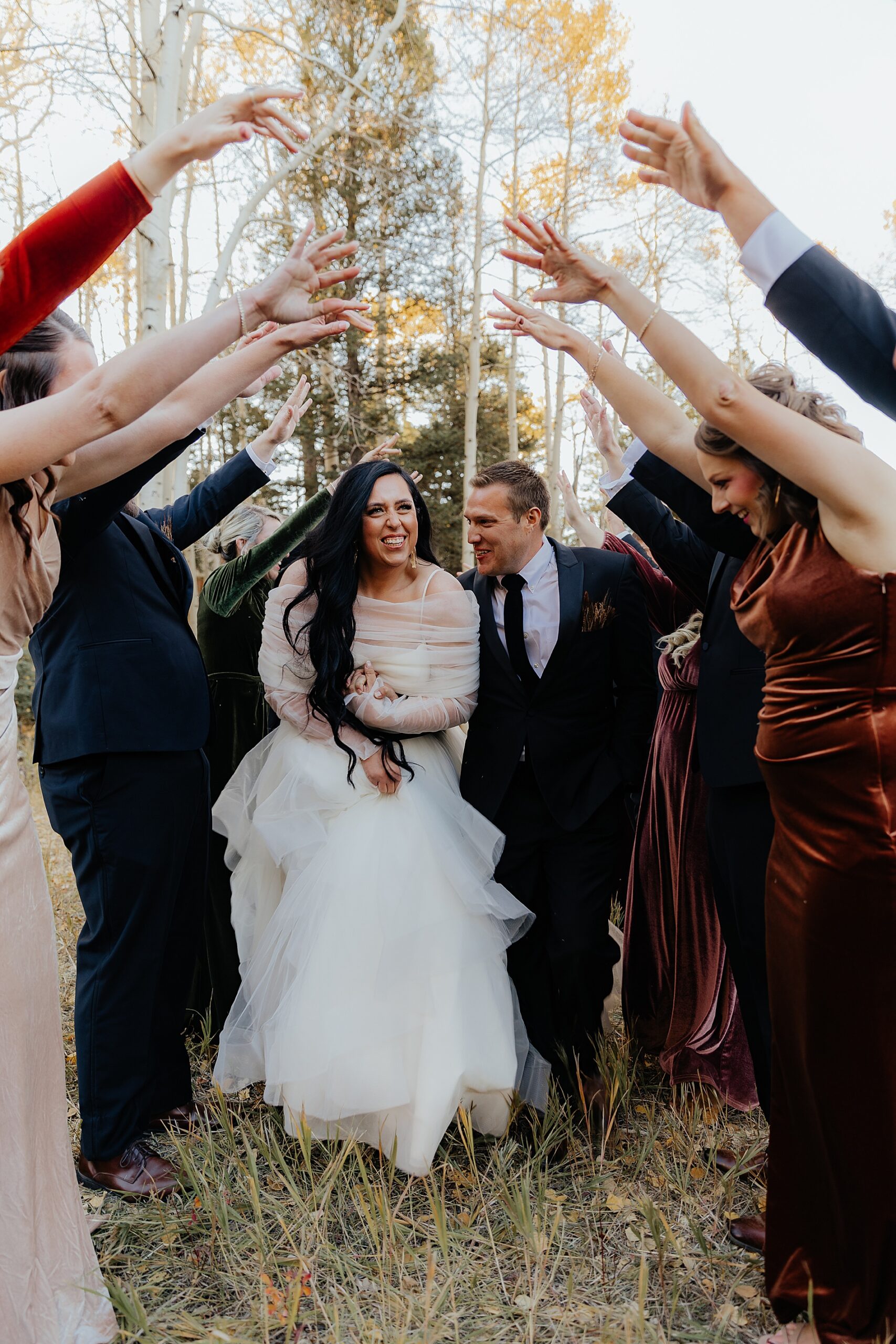 wedding party creates tunnel for bride and groom to walk through