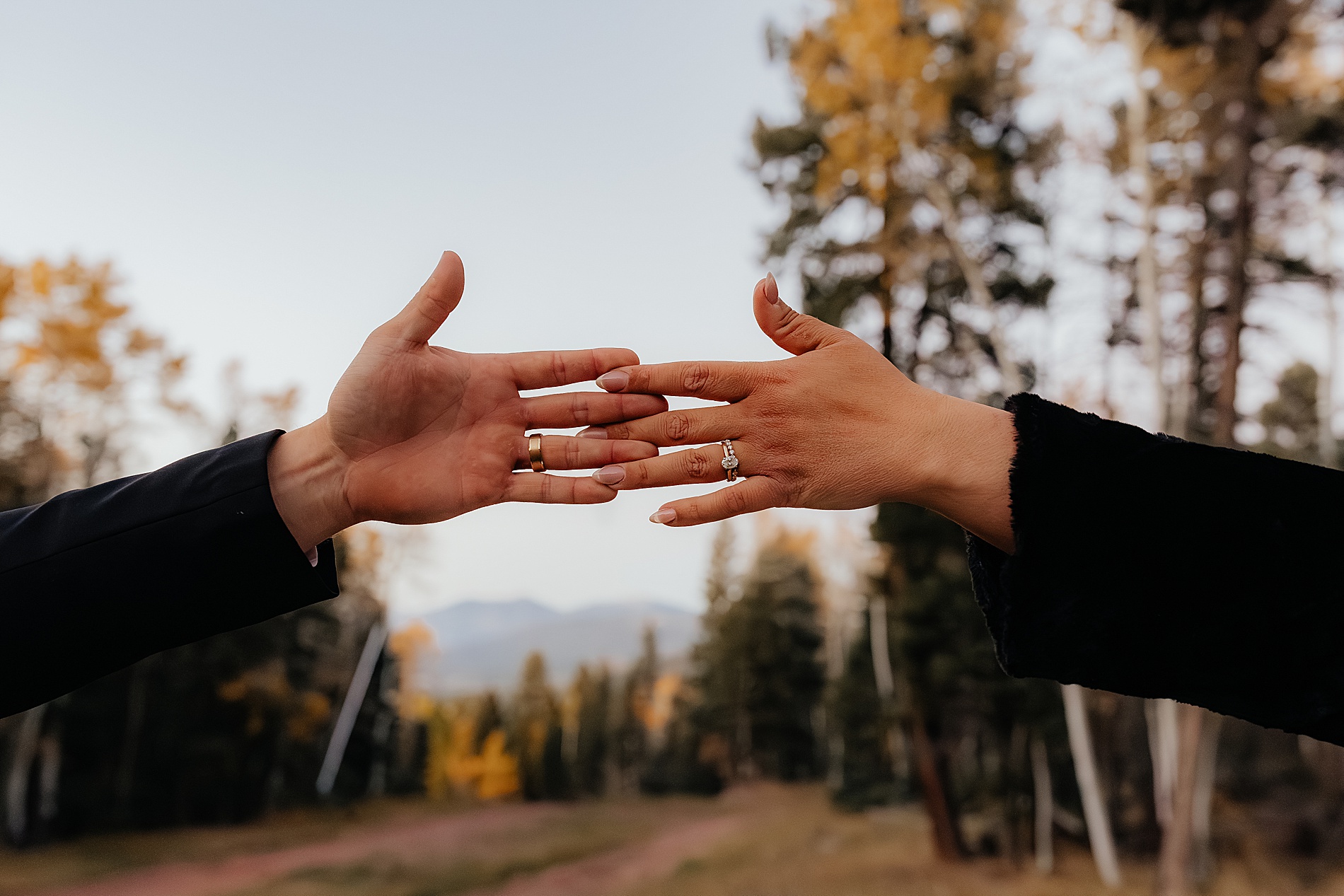 bride and groom show off wedding rings