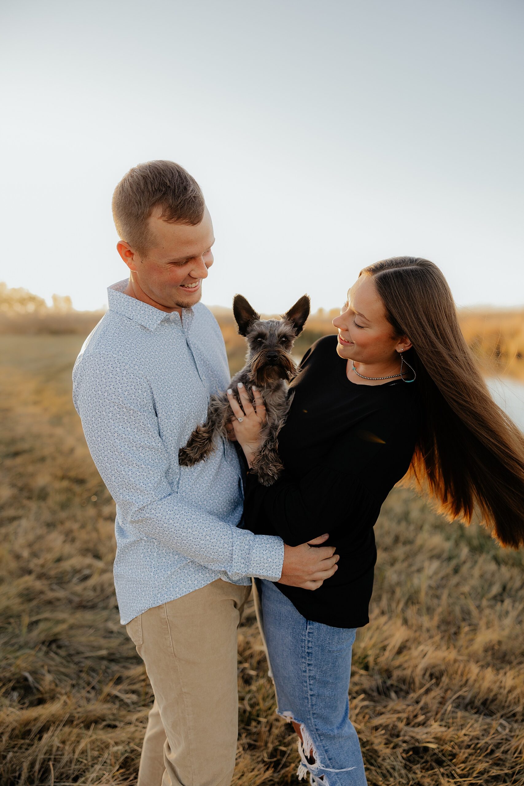 engaged couple hold their dog during engagement session