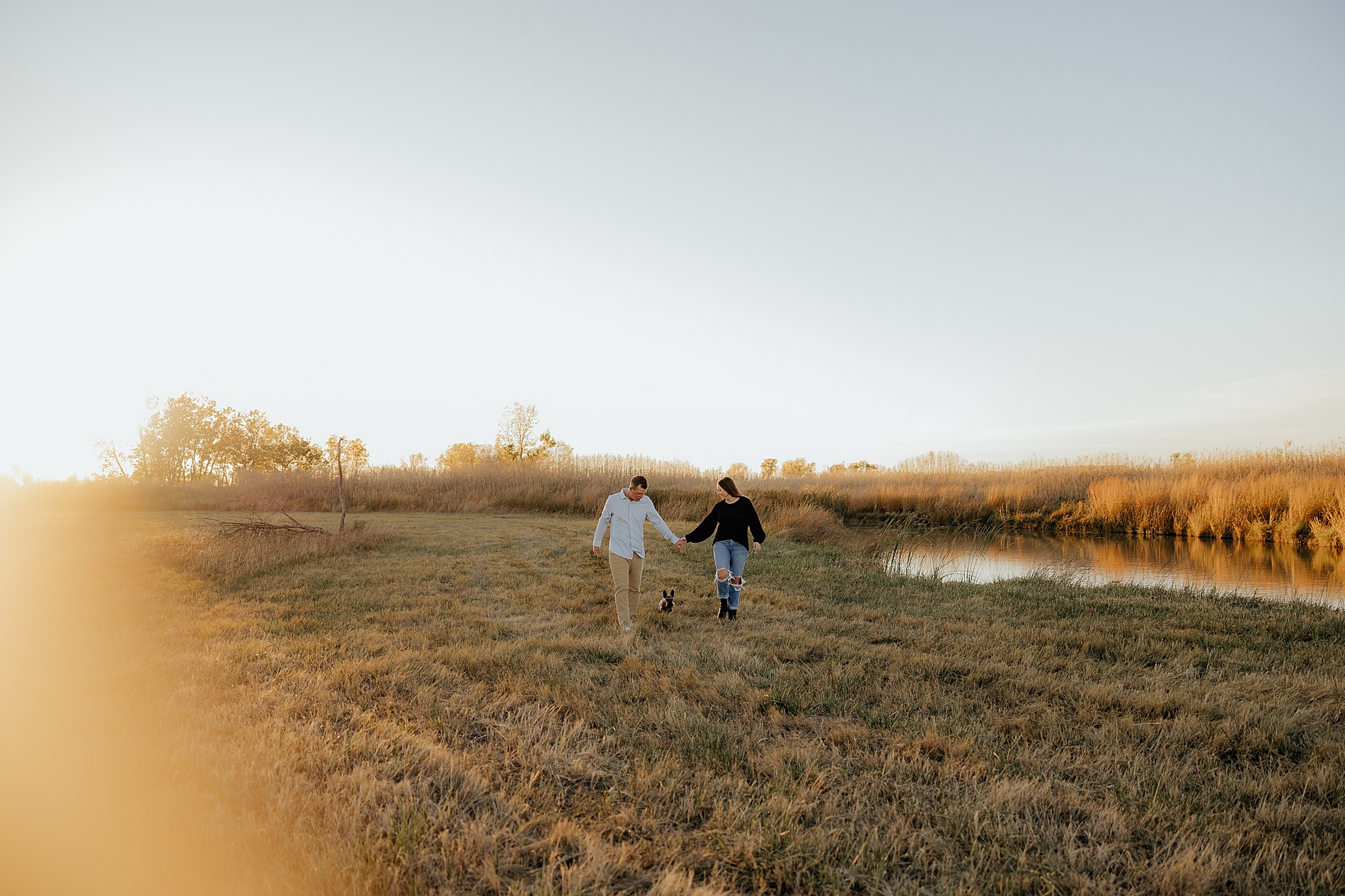 couple walk together holding hands as the sun sets