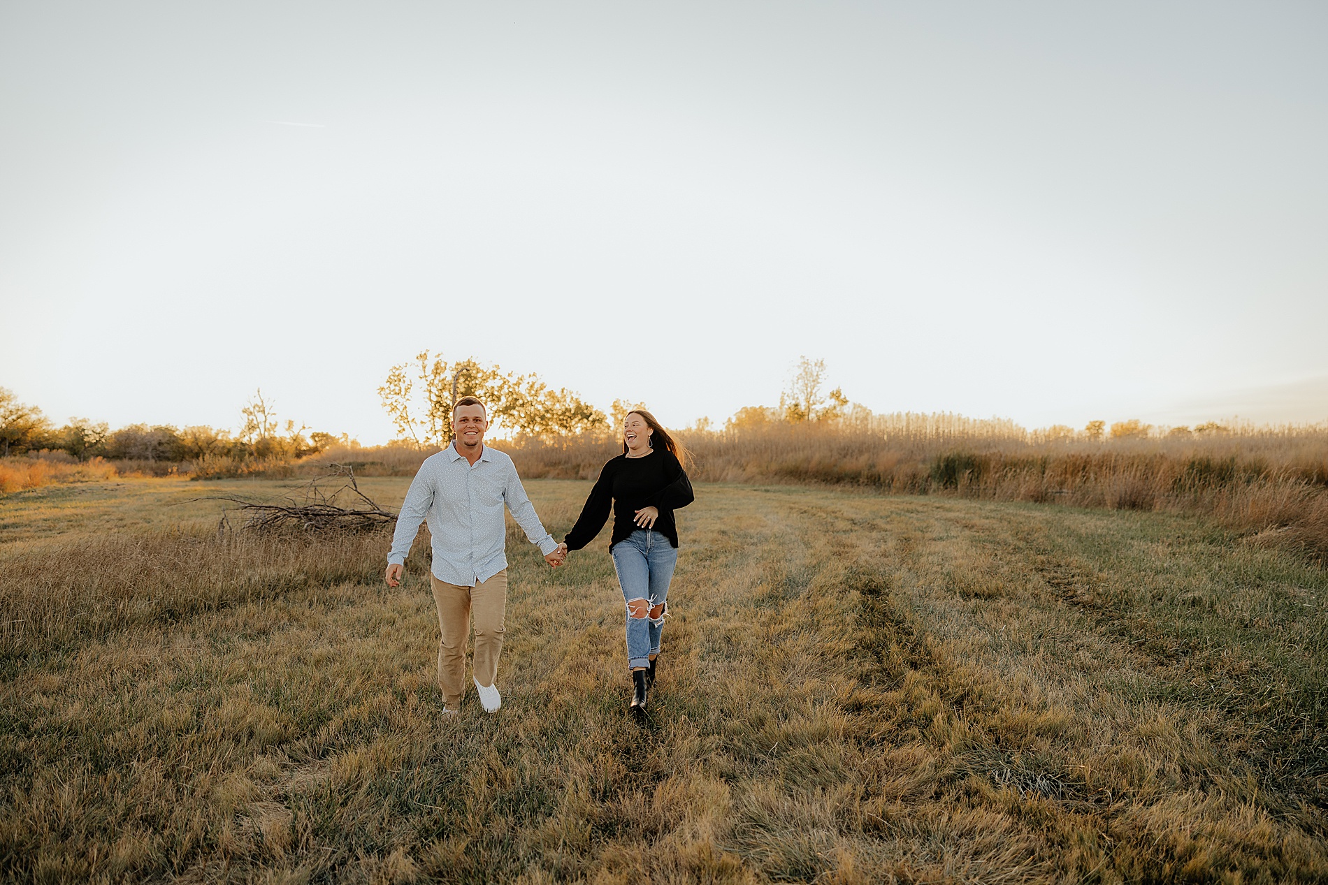 couple walk together holding hands during Texas engagement session