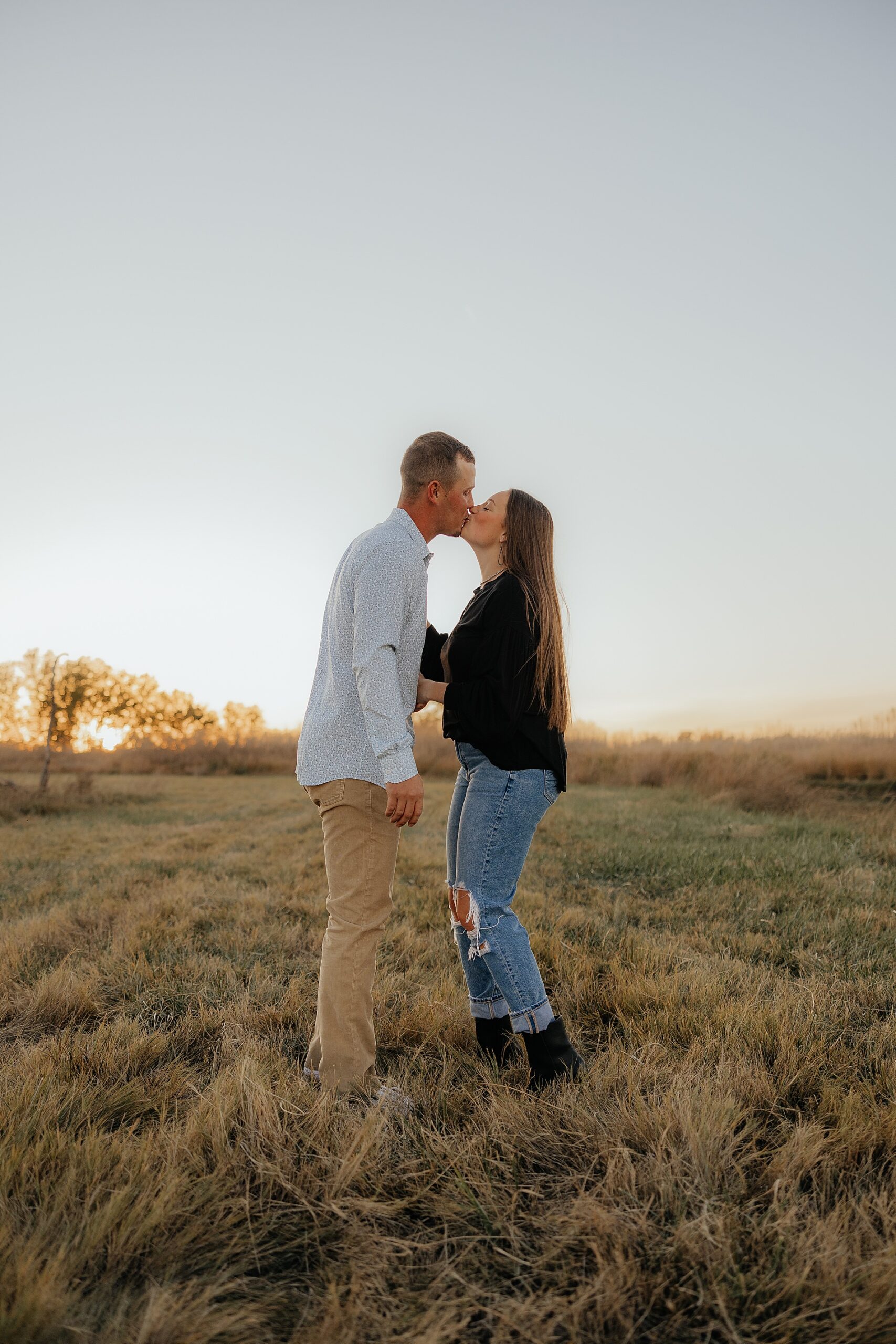 couple kisses in field