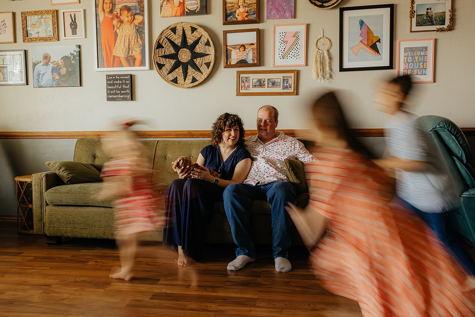 3 kids run and dance around the room while parents hold newborn | The Beauty of Candid Lifestyle Photography