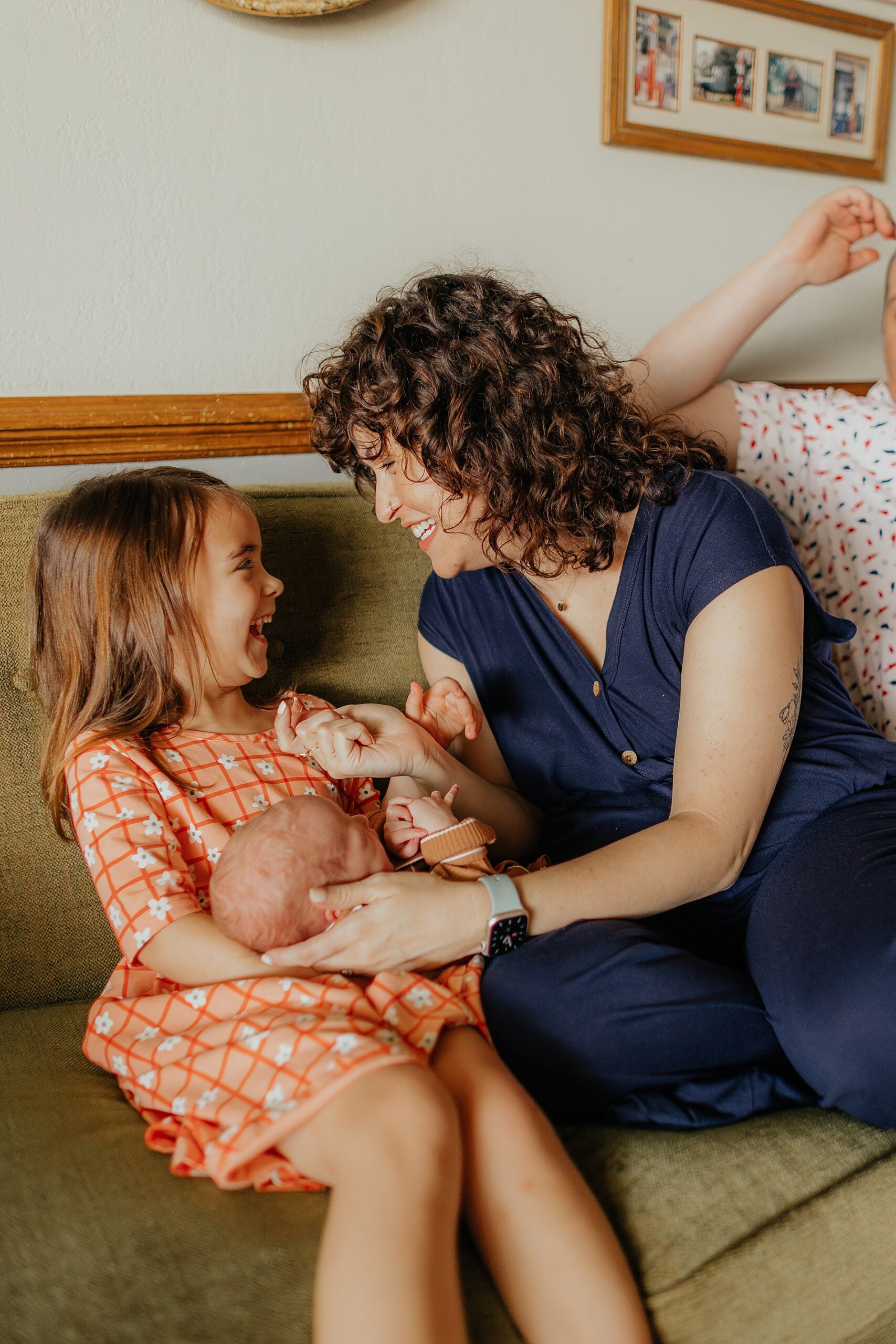 mom helps daughter hold baby brother while laughing | The Beauty of Candid Lifestyle Photography