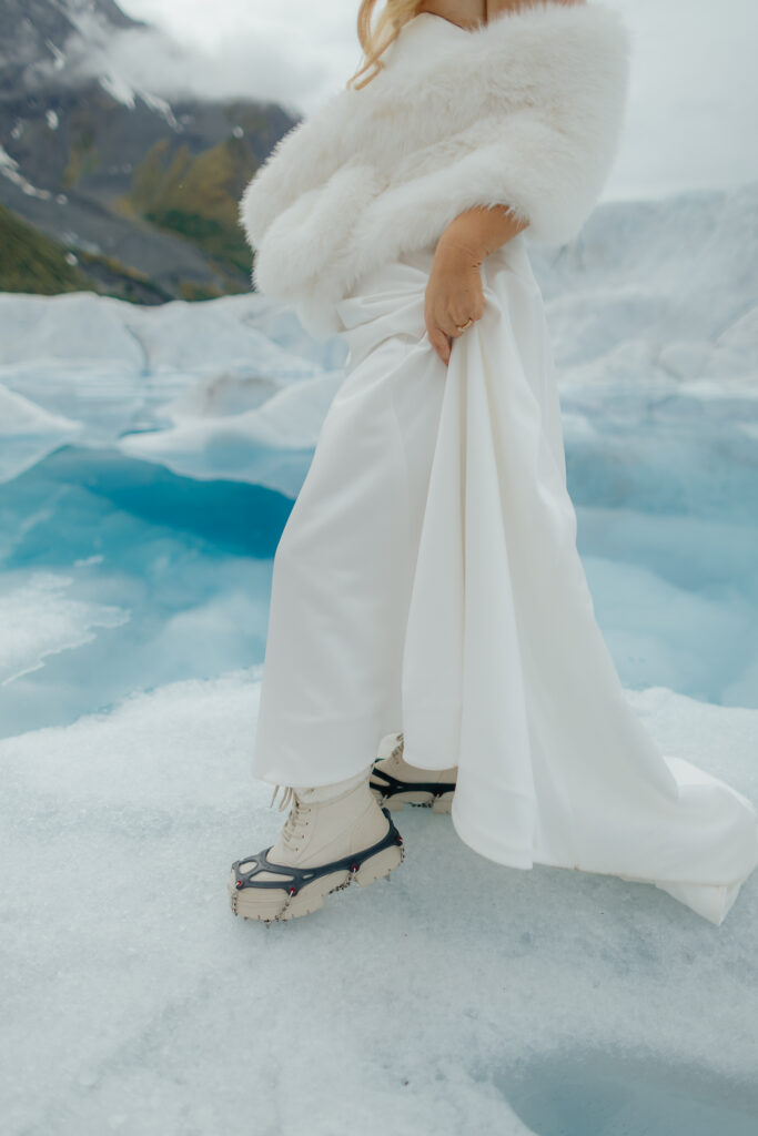 Bride wearing microspikes while exploring the blue ice of Knik Glacier.