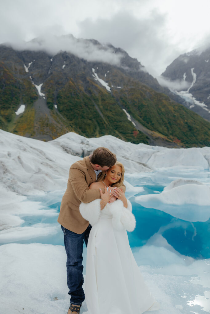 Groom hugging the bride during portraits on Knik Glacier in Alaska.