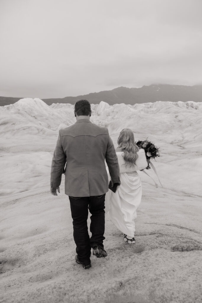 Bride and groom walking across Knik Glacier after their helicopter landing.