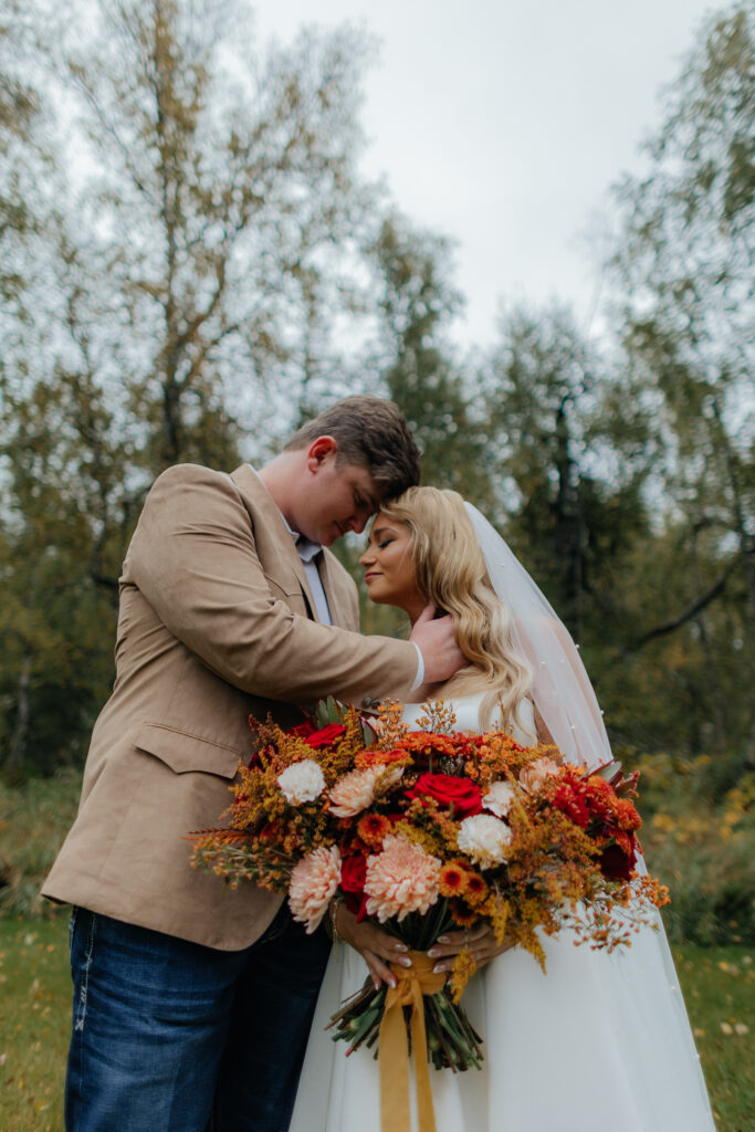Bride and groom embracing with their bouquet before boarding the helicopter.