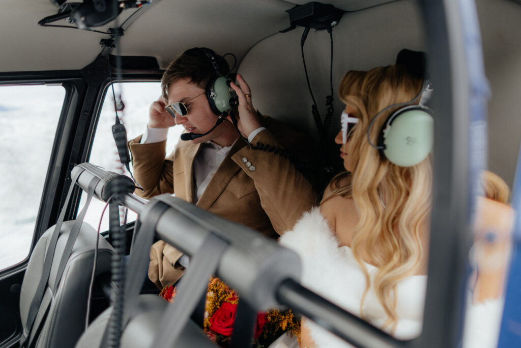 Bride and groom putting on headsets before flying away from Knik Glacier.
