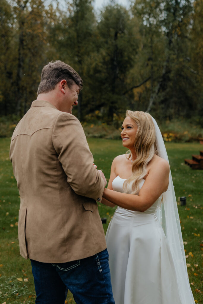 Bride and groom smiling during their first look before their Knik Glacier helicopter elopement.