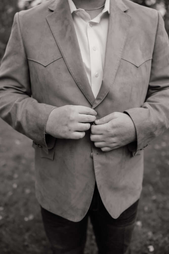 Groom adjusting his jacket before the first look at an Alaska helicopter elopement.