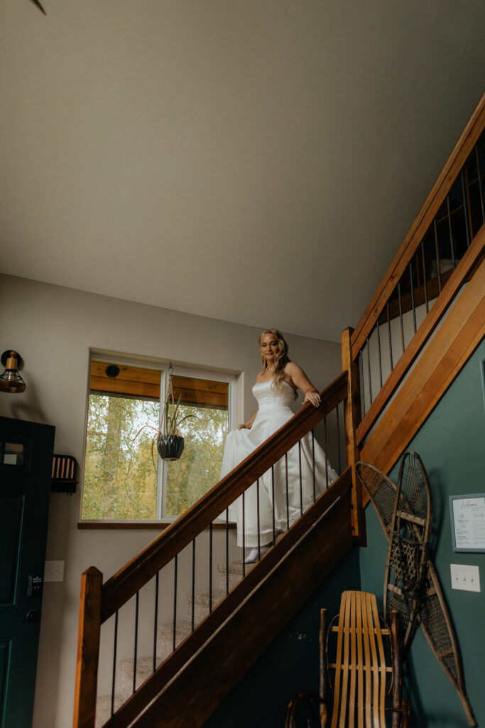 Bride walking down the cabin staircase before her first look in Alaska.