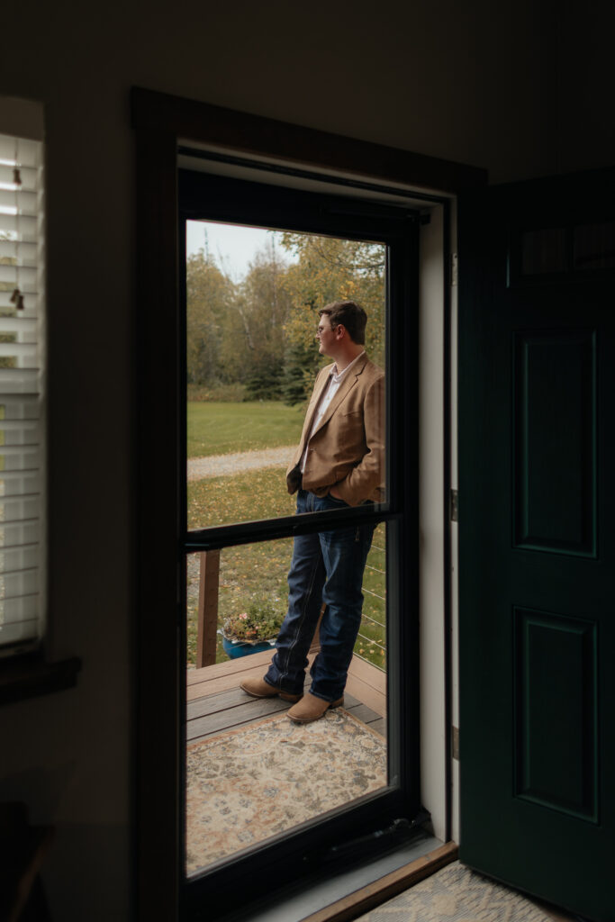 Groom waiting outside the cabin before the first look on his Alaska wedding day.