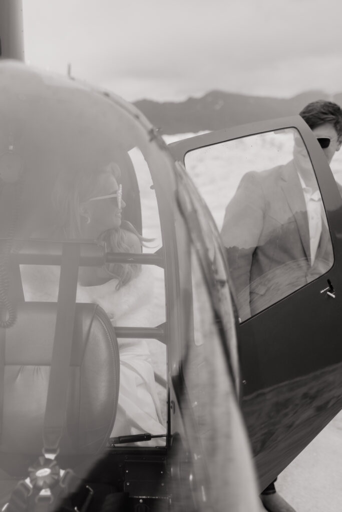 Bride and groom climbing into the helicopter after their glacier wedding in Alaska.